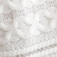 Fehér bő szabású kötött pulóver domborított mintával rojtokkal díszítve