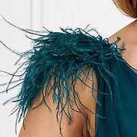 Long dark green tulle dress in a bell shape accessorized with rhinestones and feathers