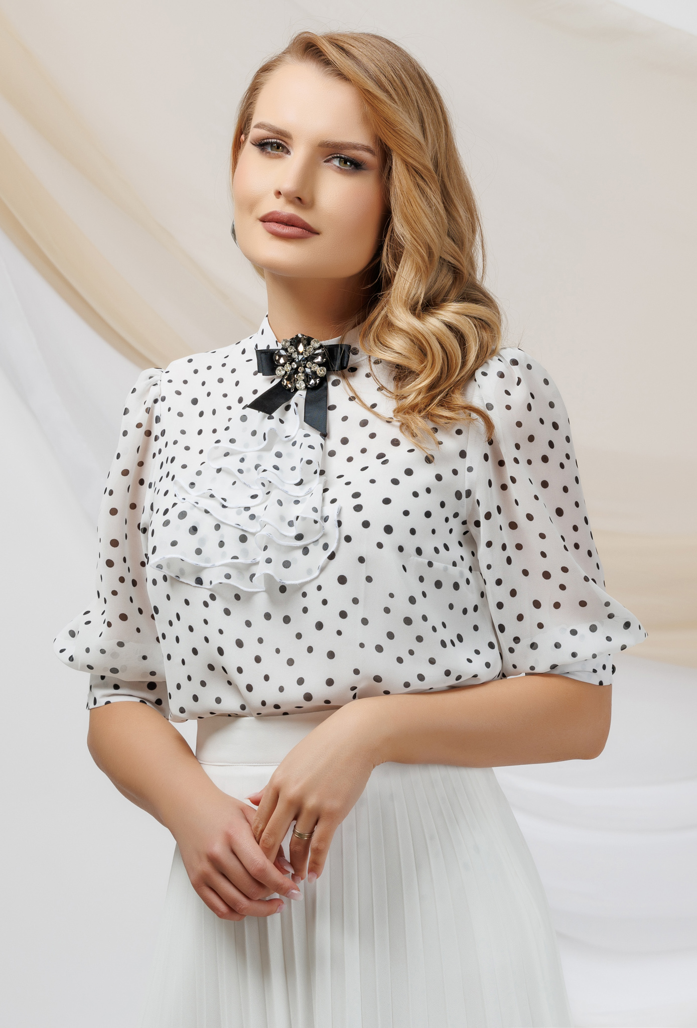 Women`s blouse from veil fabric loose fit accessorized with breastpin