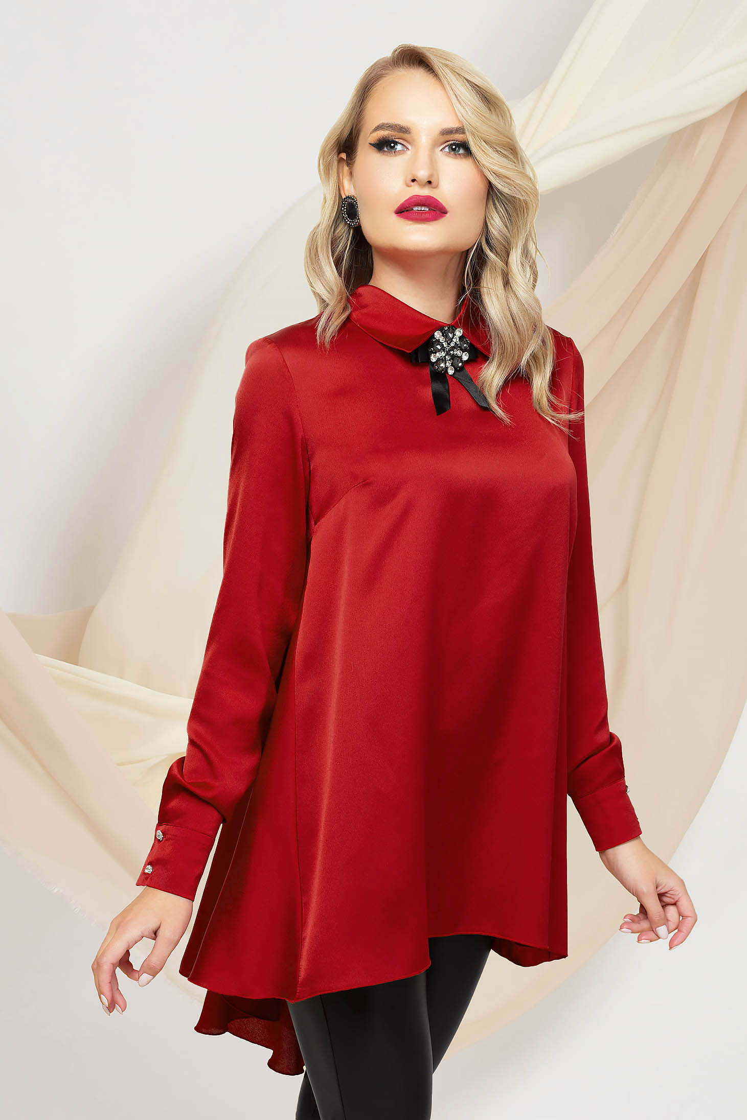 Red women`s blouse asymmetrical loose fit from satin accessorized with breastpin